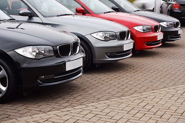 front of four parked cars