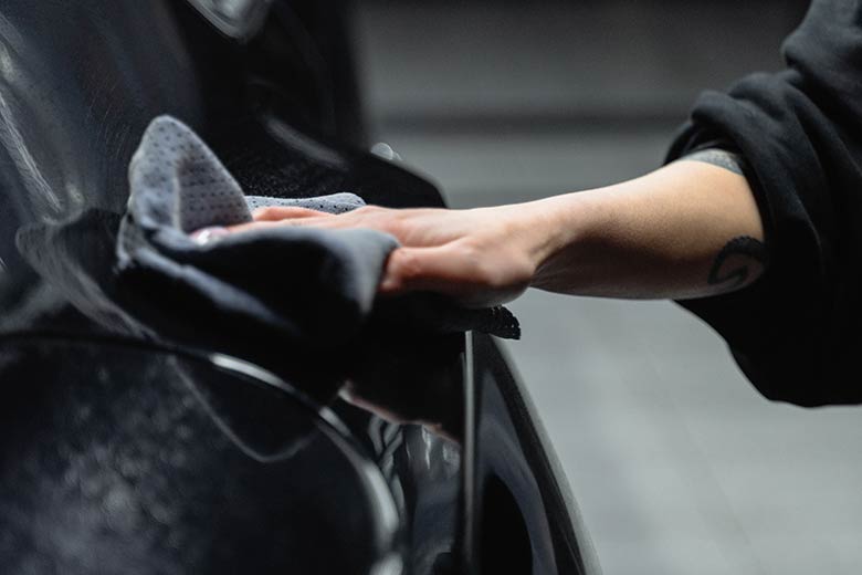 a person polishing a car